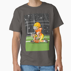 American football player kneeling in the middle of the field and with the ball in his hand Classic T-Shirt